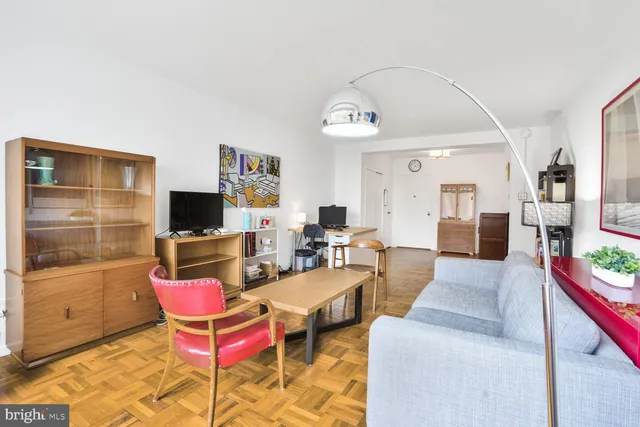 a living room with furniture a flat screen tv and a table