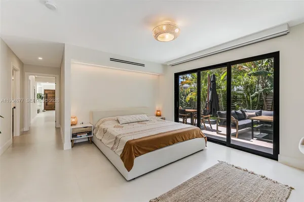 a bed sitting in a spacious bedroom next to a window