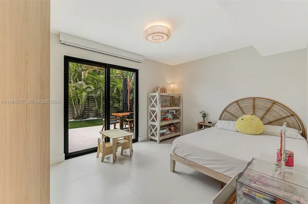 a bedroom with a bed and a refrigerator