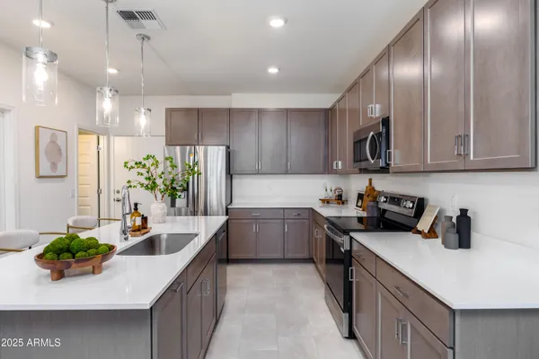 a kitchen with kitchen island granite countertop a sink a counter top space appliances and cabinets
