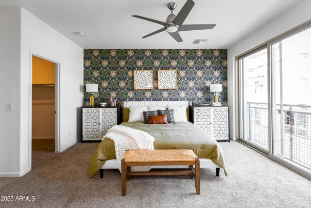 a bedroom with a bed and large window