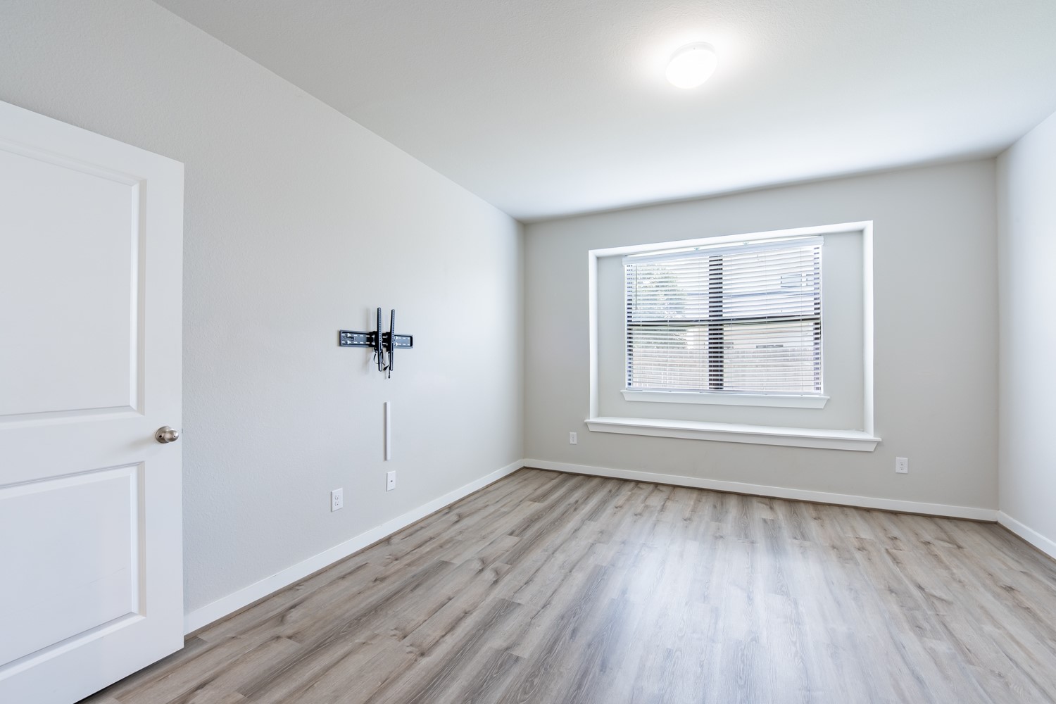 147 Waterside Road, Unit A Buda, TX 78610 - Photo 15 of 27 A well-lit room showcases durable laminate flooring and a wide window, ready for personalization.