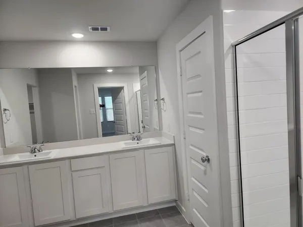 a bathroom with a double vanity sink and a mirror