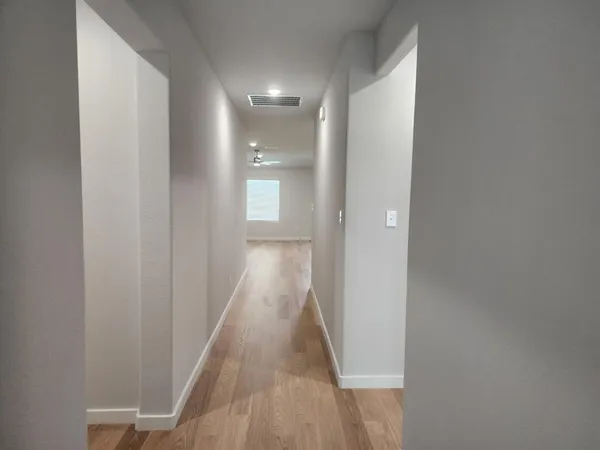 a view of a hallway with wooden floor