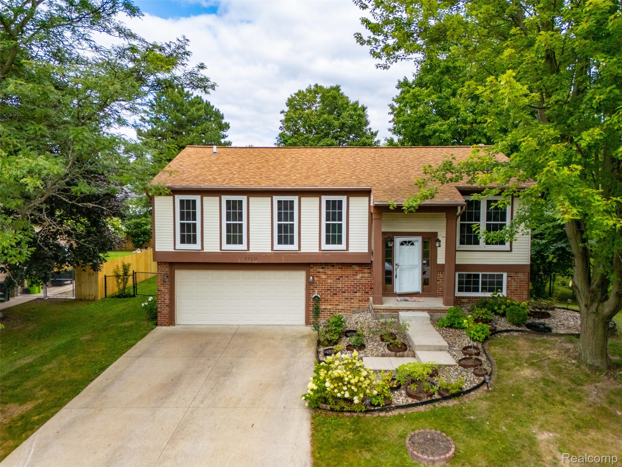 22530 Sheridan Road Novi, MI 48375 - Photo 35 of 50 Raised ranch featuring brick siding, an attached garage, concrete driveway, and roof with shingles