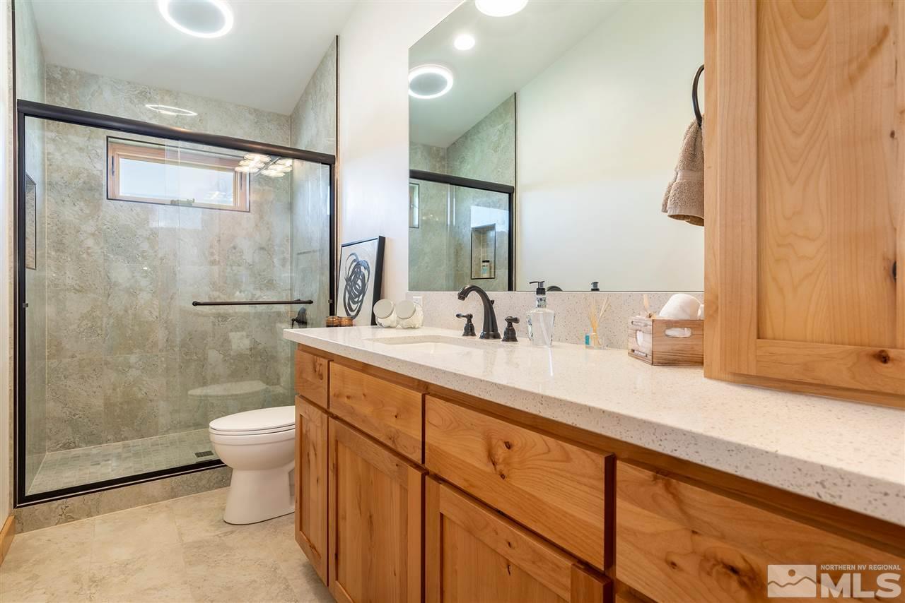 15000 North Red Rock Road Reno, NV 89508 - Photo 19 of 25 a bathroom with a granite countertop sink a toilet a mirror and shower