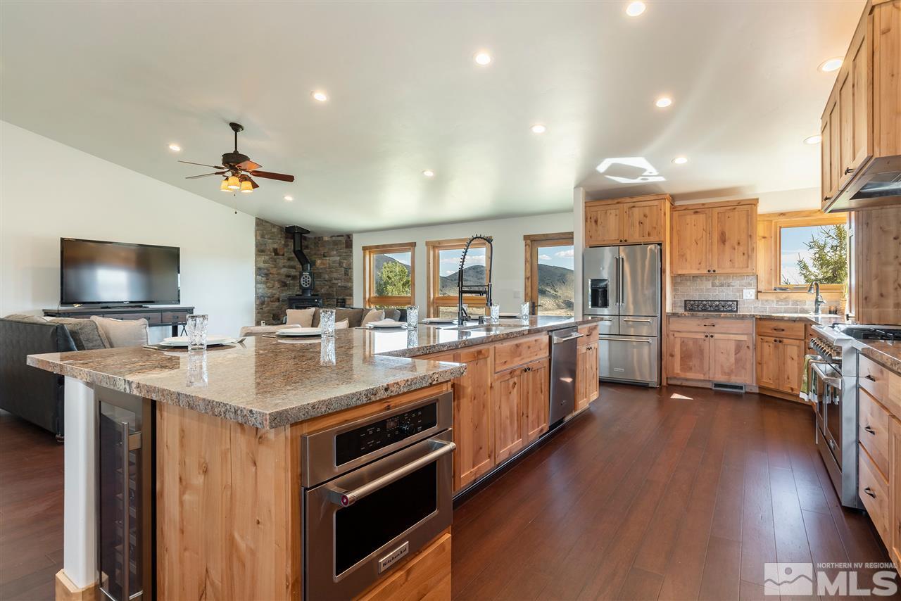 15000 North Red Rock Road Reno, NV 89508 - Photo 9 of 25 a open kitchen with stainless steel appliances kitchen island granite countertop a stove a sink dishwasher and a flat screen tv