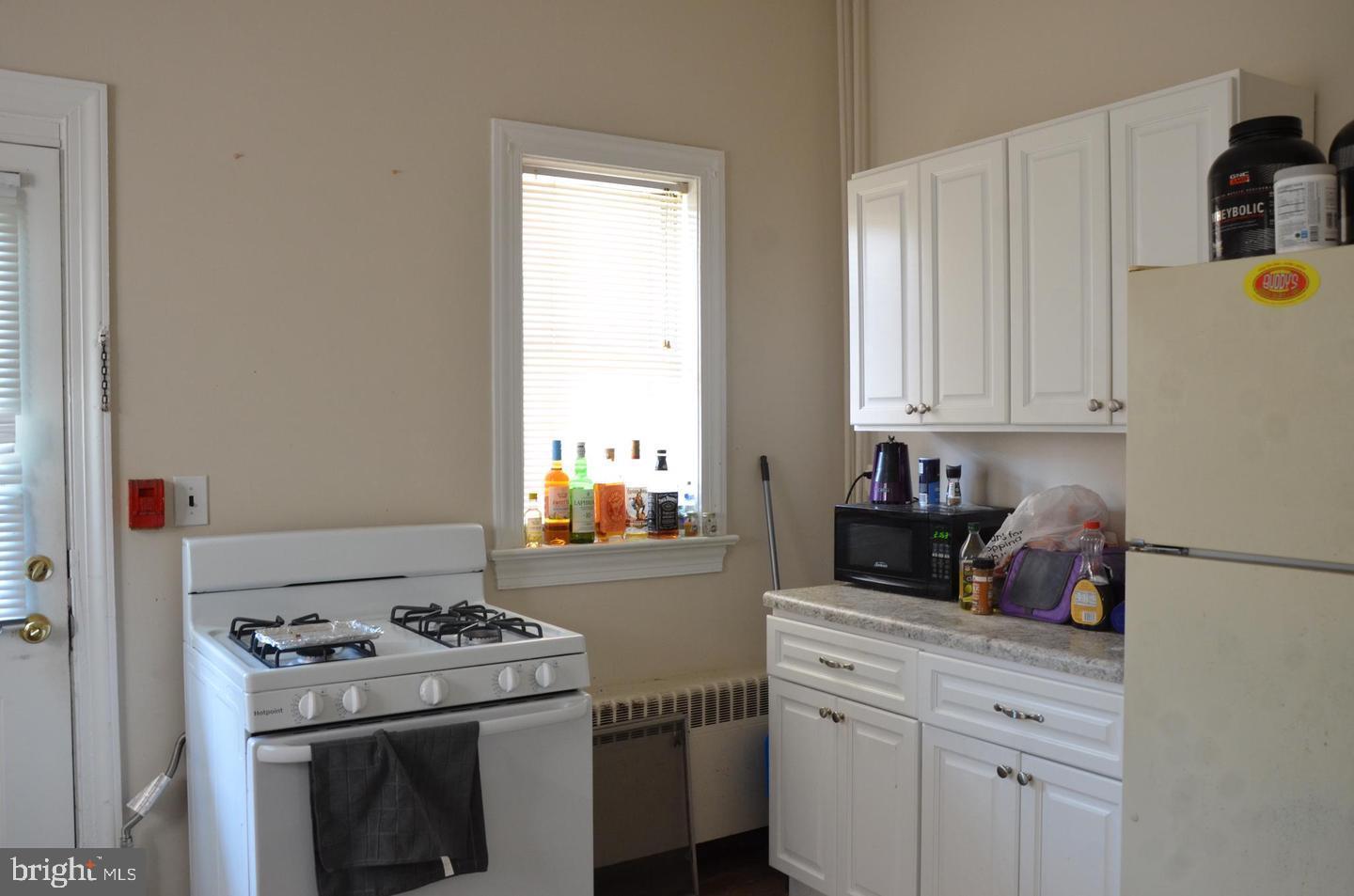 208 West Gay Street, Unit 2 West Chester, PA 19380 - Photo 10 of 12 a kitchen with a stove and white cabinets