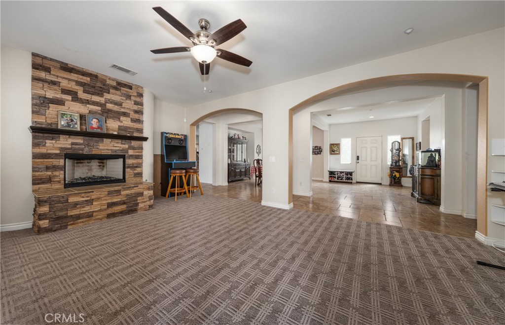 7840 La Cresta Street Highland, CA 92346 - Photo 11 of 47 a view of a livingroom with a fireplace a ceiling fan and wooden floor