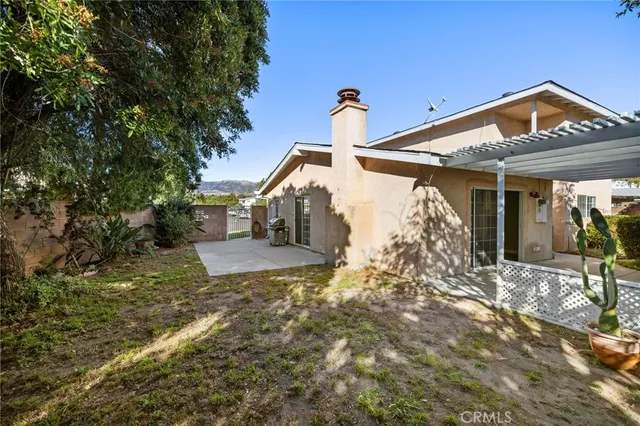 a view of a house with backyard and sitting area