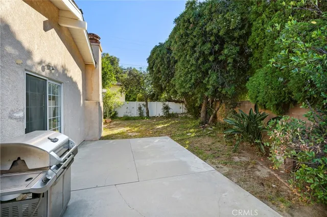 a view of backyard with barbeque grill and seating area