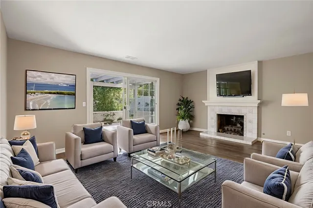 a living room with furniture a fireplace a flat screen tv and a large window