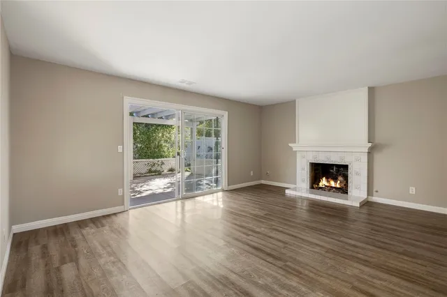 a view of an empty room with a window and fire place