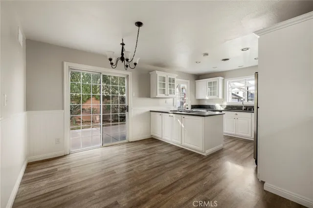 a view of kitchen with granite countertop cabinets and refrigerator