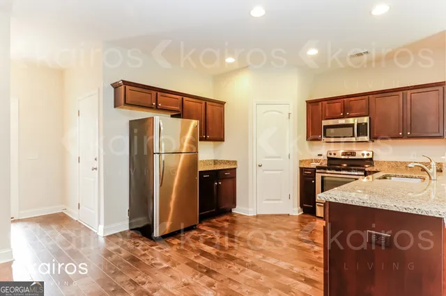 a kitchen with stainless steel appliances granite countertop a refrigerator stove and a sink