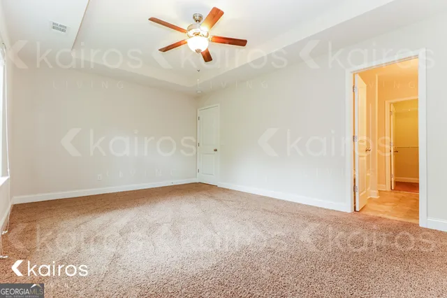 an empty room with a ceiling fan and a window