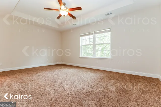 an empty room with windows and fan