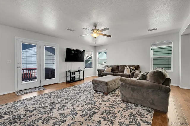 a living room with furniture and a wooden floor