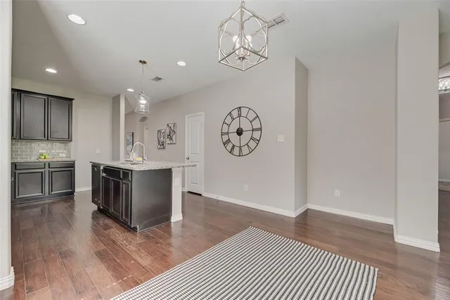 a view of a kitchen with a sink a refrigerator and wooden floor