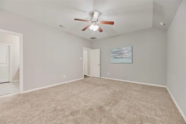 an empty room with fan and windows