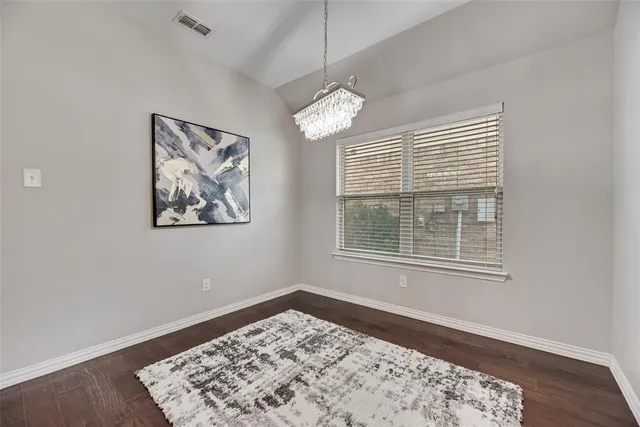 a view of a bedroom with wooden floor and windows