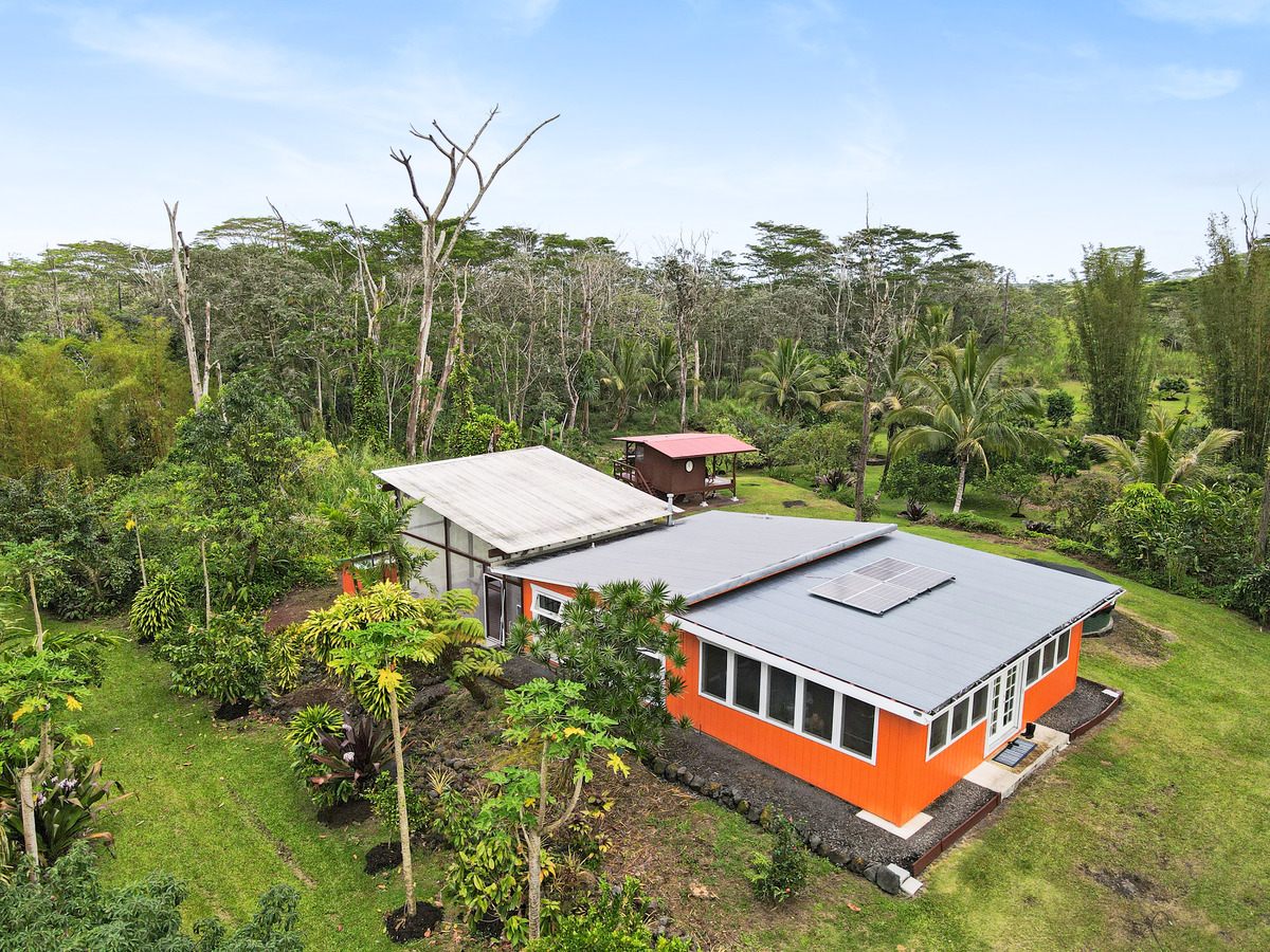 aerial view of a house with balcony and trees al around