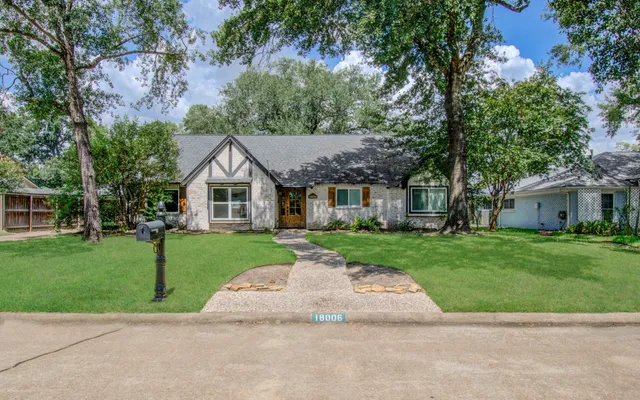 a aerial view of a house next to a yard with big trees