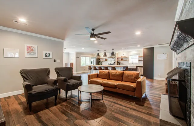 a living room with furniture and a view of kitchen