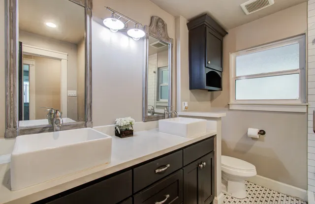 a bathroom with a sink a toilet and a mirror