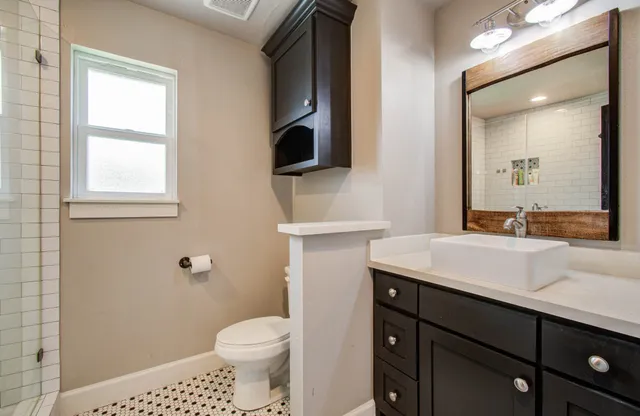 a bathroom with a sink toilet and mirror