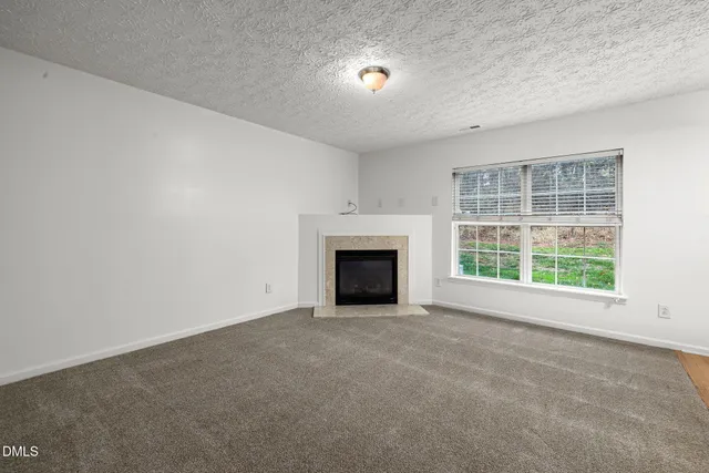 an empty room with a fireplace and window