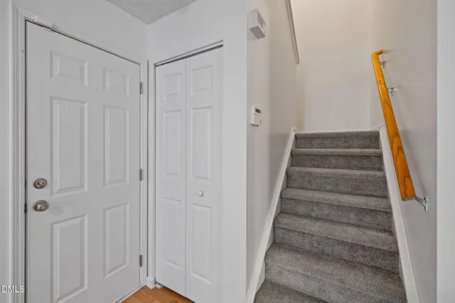 a view of staircase with white walls and white door