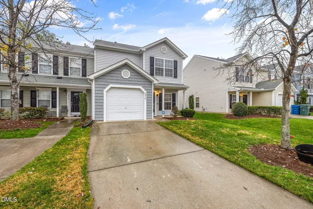 a front view of a house with a yard and trees