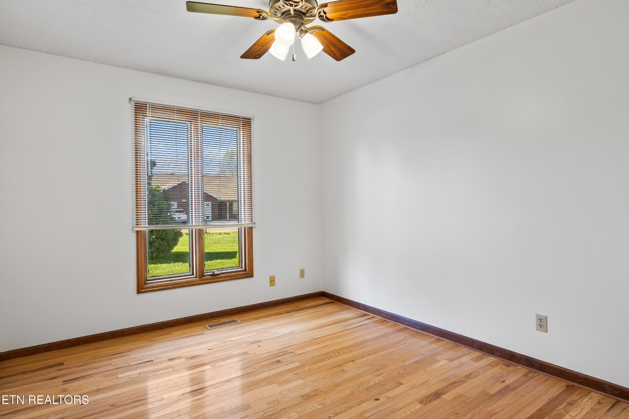 3941 Simpson Road Lenoir City, TN 37772 - Photo 23 of 35 an empty room with wooden floor chandelier and windows