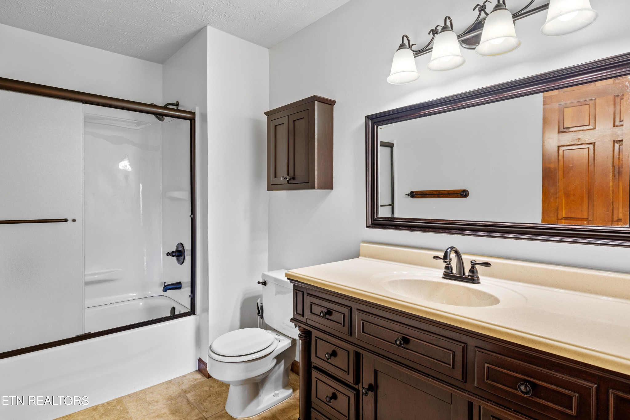 3941 Simpson Road Lenoir City, TN 37772 - Photo 24 of 35 a bathroom with a sink a toilet a mirror and shower