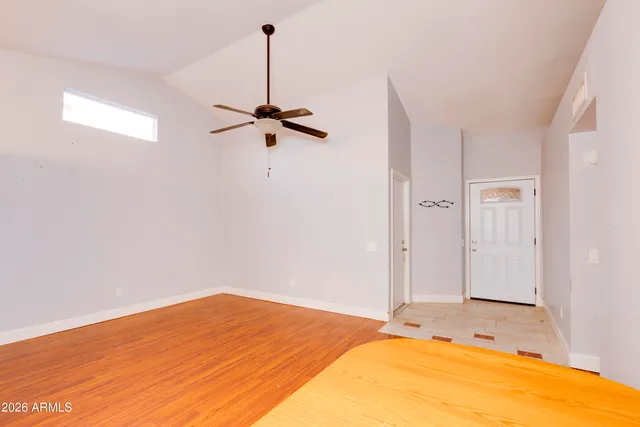 a view of a room with a wooden floor and a ceiling fan