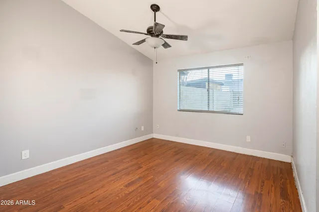 a view of wooden floor and a chandelier fan in a room