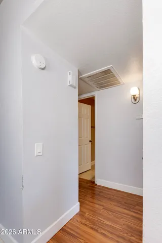 a view of empty room with wooden floor