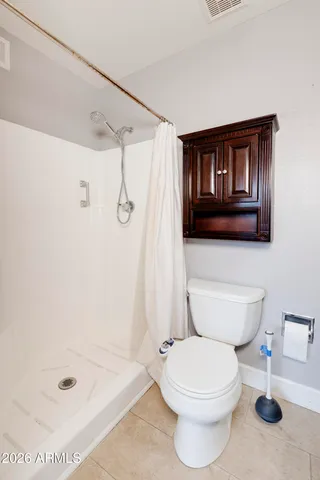 a bathroom with a toilet and a shower