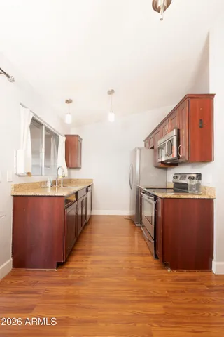 a kitchen with stainless steel appliances granite countertop a stove a sink and a microwave