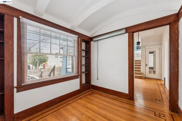 a view of hallway with a large window and wooden floor