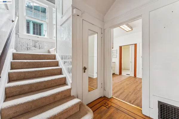 a view of a hallway with wooden floor and staircase