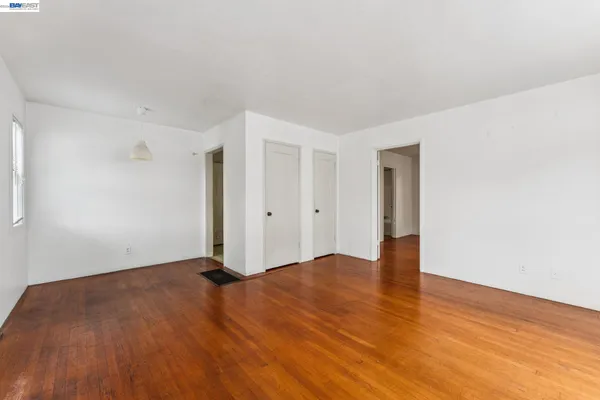 a view of an empty room with wooden floor