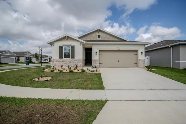 a front view of a house with a yard and garage
