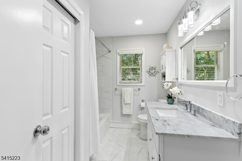 33 Carol Road Westfield, NJ 07090 - Photo 17 of 23 a spacious bathroom with a granite countertop sink mirror and a bathtub