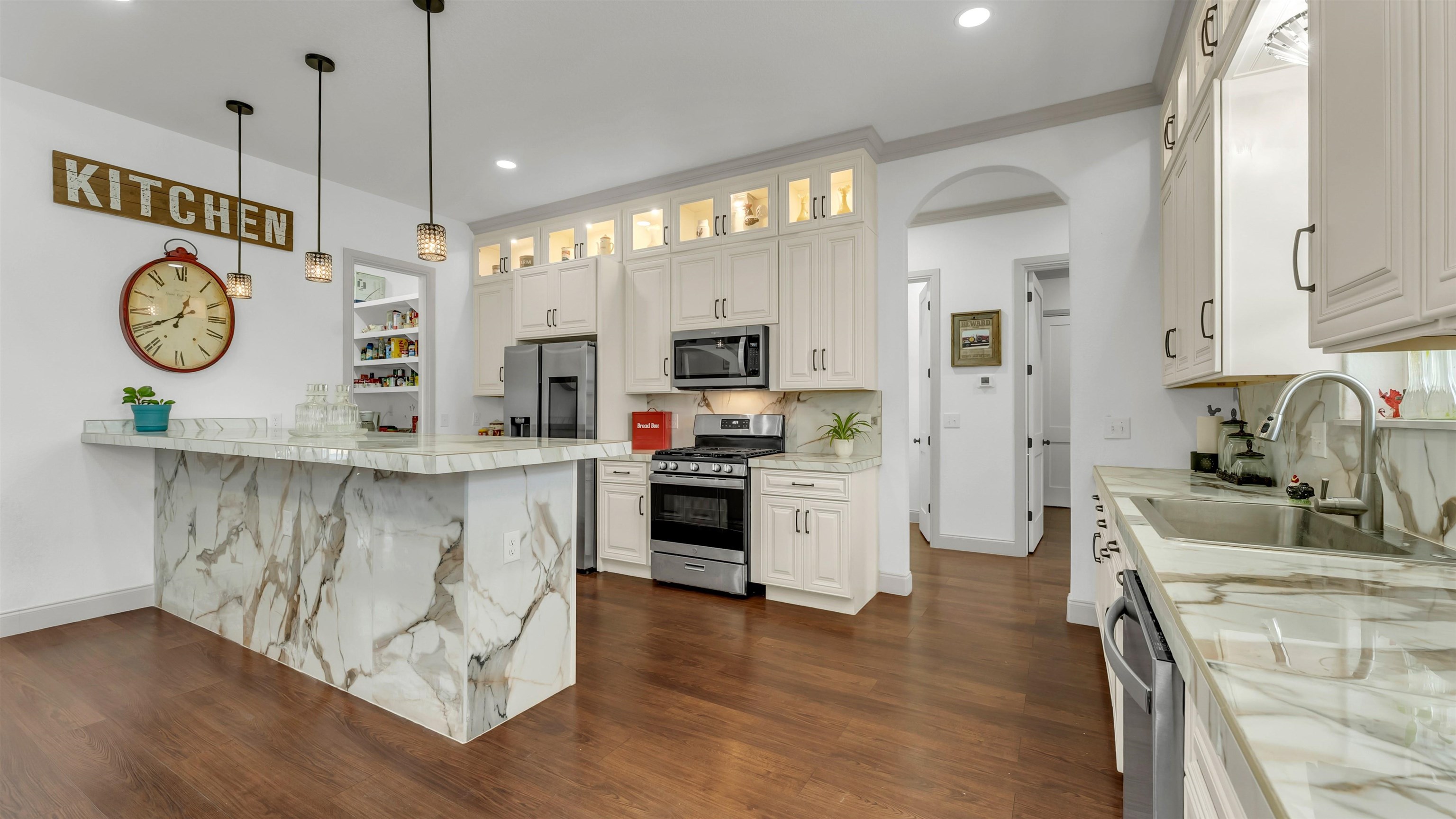 292 Oak Ridge Trail Kingsland, TX 78639 - Photo 12 of 29 a open kitchen with stainless steel appliances granite countertop a stove a sink dishwasher a refrigerator and a fireplace with wooden floor