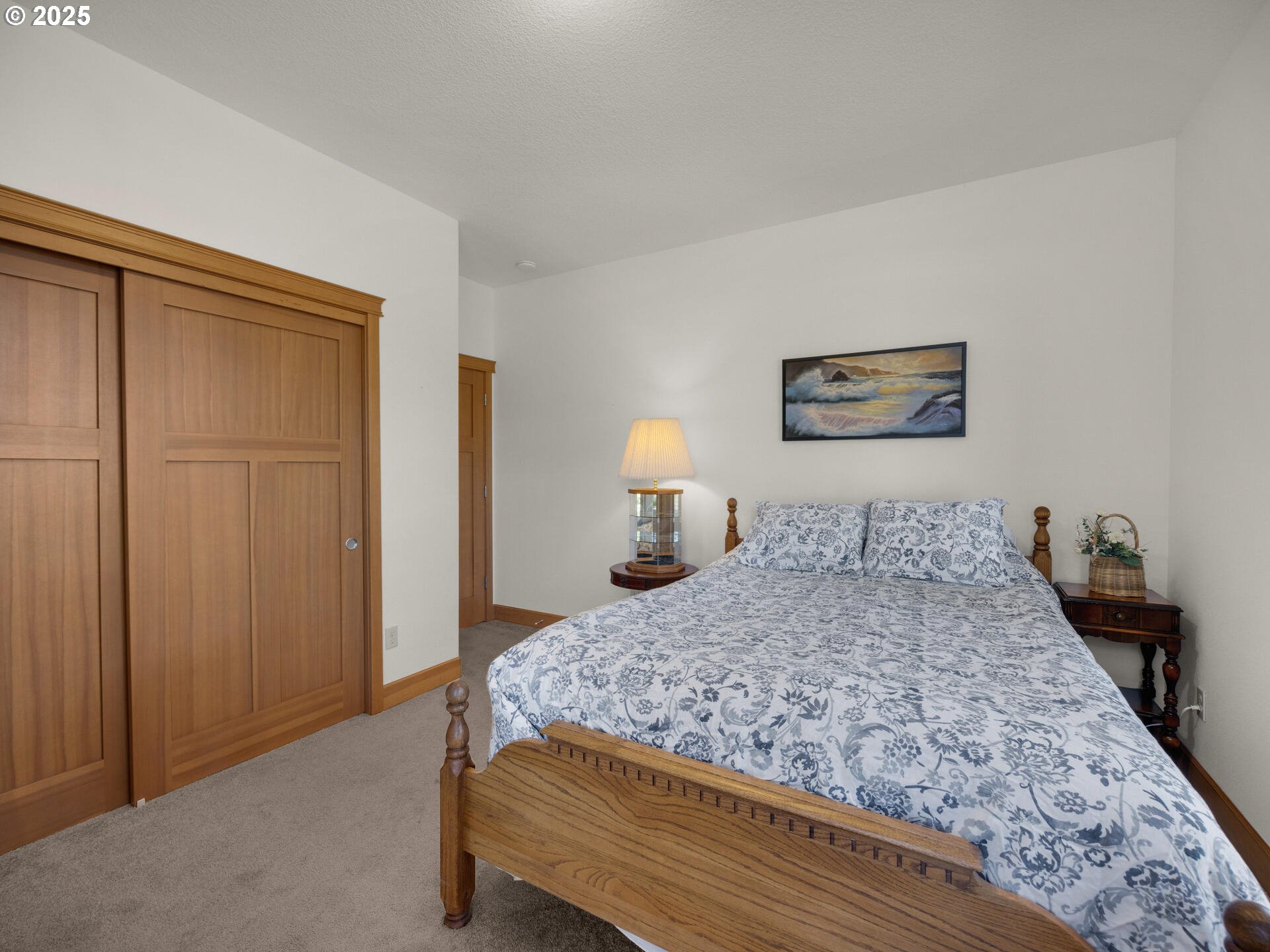 34535 Pinyon Drive Nehalem, OR 97131 - Photo 21 of 41 a bedroom with a large bed and a chandelier