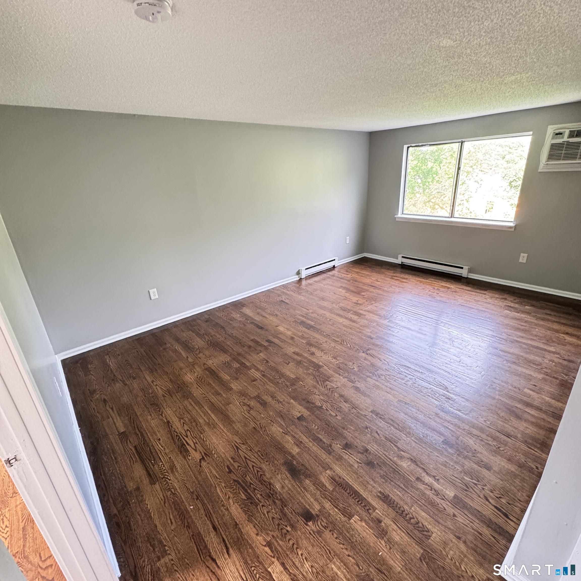 32 Old Foxon Road, Unit 42 East Haven, CT 06513 - Photo 4 of 4 an empty room with wooden floor and windows