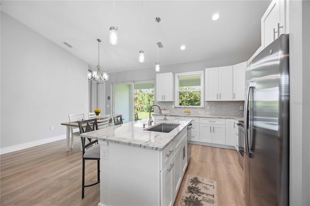 10443 Riverside Road Port Charlotte, FL 33981 - Photo 15 of 64 a kitchen with stainless steel appliances granite countertop sink refrigerator and microwave