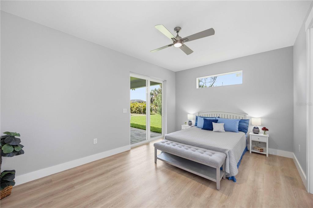 10443 Riverside Road Port Charlotte, FL 33981 - Photo 16 of 64 a bedroom with a bed and a chandelier